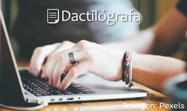 manos en el teclado de una notebook tipeando qué es una dactilógrafa